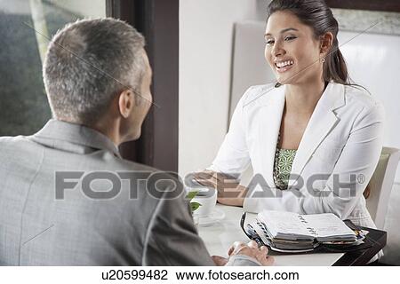 Two businesspeople meeting in café View Large Photo Image Stock Image - Two businesspeople meeting in café. Fotosearch