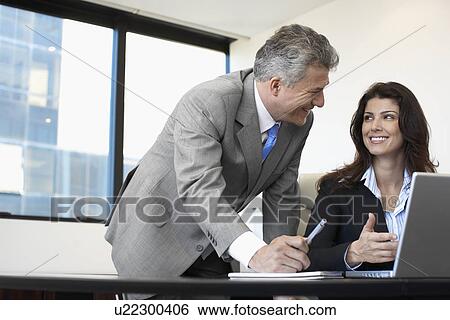 Two businesspeople working on laptop View Large Photo Image Stock Photograph - Two businesspeople working on laptop. Fotosearch