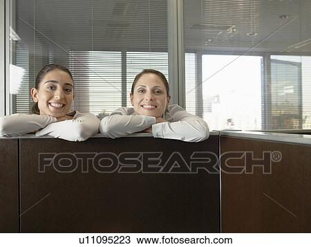 Two office workers leaning against partition wall (portrait) View Large Photo Image Stock Image - Two office workers leaning against partition wall (portrait). Fotosearch