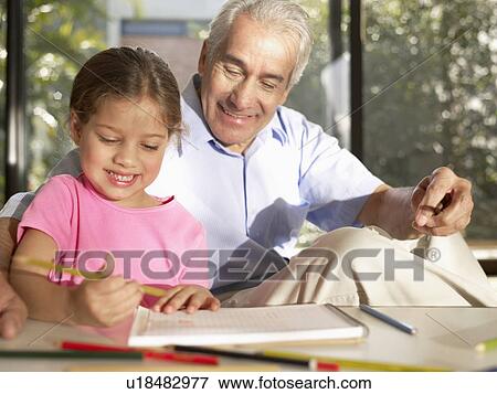 Stock Photo - Grandfather and granddaughter drawing with colored pencils. Fotosearch