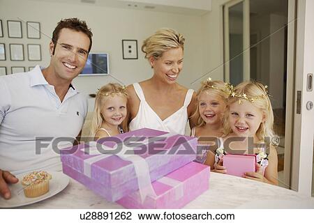 Stock Image - Parents and triplets having birthday party. Fotosearch