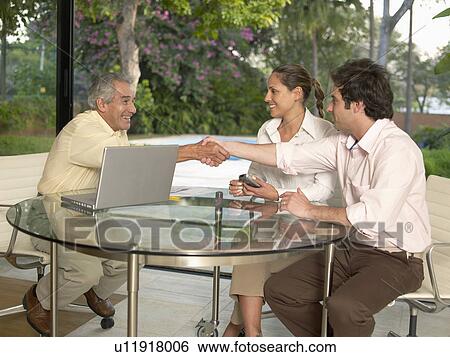 Stock Photograph - Businesspeople meeting in living room. Fotosearch