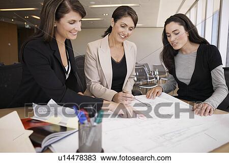 Three businesswomen examining blueprint View Large Photo Image Stock Image - Three businesswomen examining blueprint. Fotosearch
