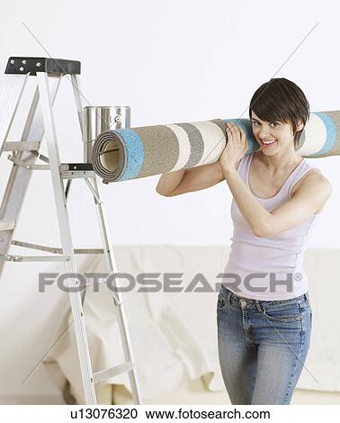 Stock Image - Young Woman Carrying Rug. Fotosearch