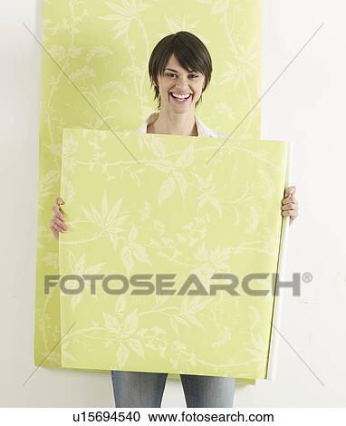 Stock Image - Young Woman Holding Wallpaper . Fotosearch