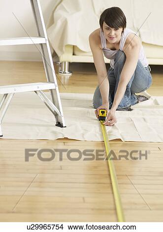 Picture - Young Woman Measuring Floor. Fotosearch