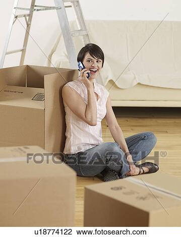 Young Woman on Cell Phone by Cardboard Boxes View Large Photo Image Stock Image - Young Woman on Cell Phone by Cardboard Boxes. Fotosearch
