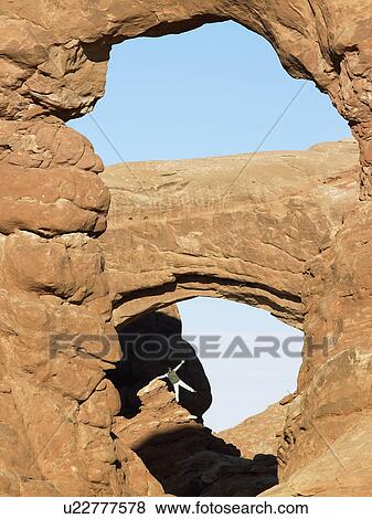 Man standing on rock in distance View Large Photo Image Stock Photo - Man standing on rock in distance. Fotosearch