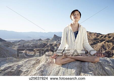 Picture - Woman meditating in lotus position in desert, Death Valley, California, USA. Fotosearch
