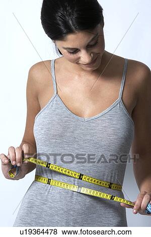 Young woman measuring waist View Large Photo Image Stock Photo - Young woman measuring waist. Fotosearch