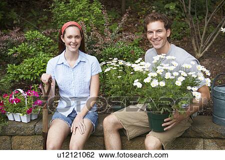 Stock Image - Gardeners sitting on wall (portrait). Fotosearch