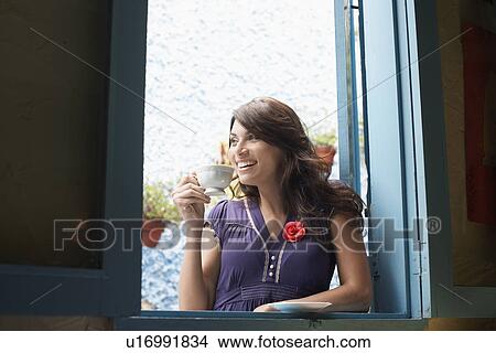Woman drinking tea at window View Large Photo Image Picture - Woman drinking tea at window. Fotosearch