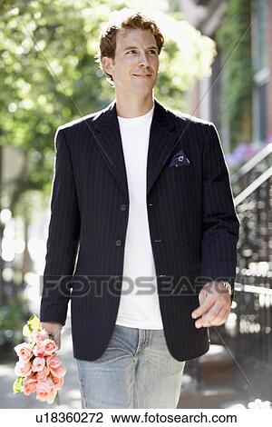 Young man carrying bunch of roses View Large Photo Image Stock Image - Young man carrying bunch of roses. Fotosearch