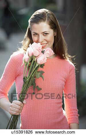 Young woman smelling flowers View Large Photo Image Stock Photograph - Young woman smelling flowers. Fotosearch