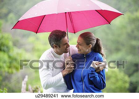 Couple with umbrella hugging near forest View Large Photo Image Stock Image - Couple with umbrella hugging near forest. Fotosearch