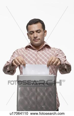 Man feeding paper to paper shredder View Large Photo Image Stock Image - Man feeding paper to paper shredder. Fotosearch