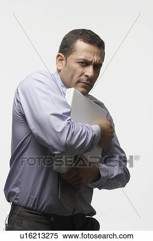 Man holding and protecting laptop computer View Large Photo Image Stock Photography - Man holding and protecting laptop computer. Fotosearch