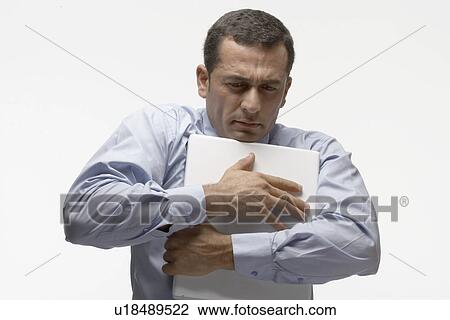 Stock Image - Man holding laptop computer. Fotosearch