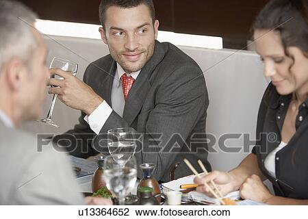 Businessman looking at woman eating sushi View Large Photo Image Stock Image - Businessman looking at woman eating sushi. Fotosearch