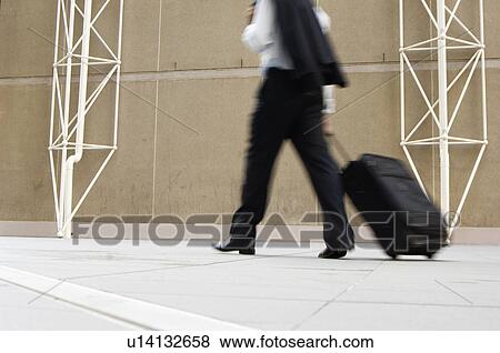 Businessman pulling briefcase (low section) View Large Photo Image Stock Photo - Businessman pulling briefcase (low section). Fotosearch