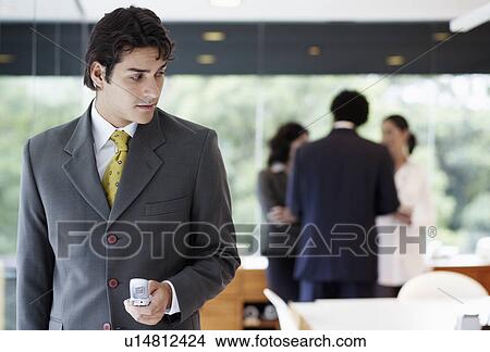 Businessman using cell phone in boardroom View Large Photo Image Picture - Businessman using cell phone in boardroom. Fotosearch