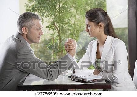 Stock Photo - Businesswoman and businessman arm wrestling. Fotosearch