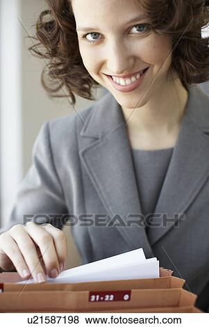 Stock Photo - Businesswoman going through files. Fotosearch