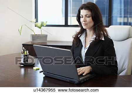 Stock Photography - Businesswoman working on laptop. Fotosearch