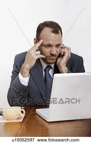 Mid Adult Man Using Laptop and Mobile Phone View Large Photo Image Stock Photo - Mid Adult Man Using Laptop and Mobile Phone. Fotosearch