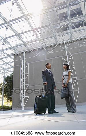 Two businesspeople talking in lobby (low angle view) View Large Photo Image Stock Photo - Two businesspeople talking in lobby (low angle view). Fotosearch
