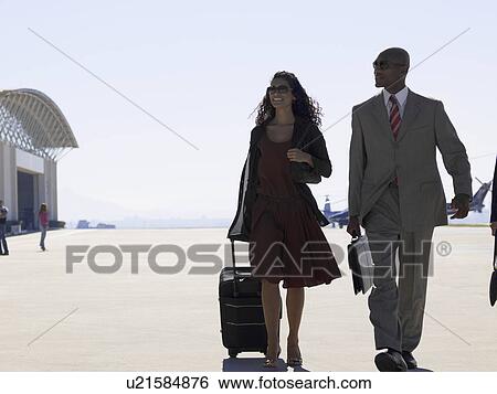 Two businesspeople walking at airport View Large Photo Image Stock Photograph - Two businesspeople walking at airport. Fotosearch