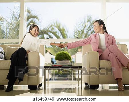 Stock Photo - Two businesswomen shaking hands. Fotosearch