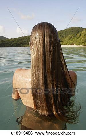 Mid adult woman standing in ocean (rear view), St. John, US Virgin Islands, USA View Large Photo Image Stock Photograph - Mid adult woman standing in ocean (rear view), St. John, US Virgin Islands, USA. Fotosearch