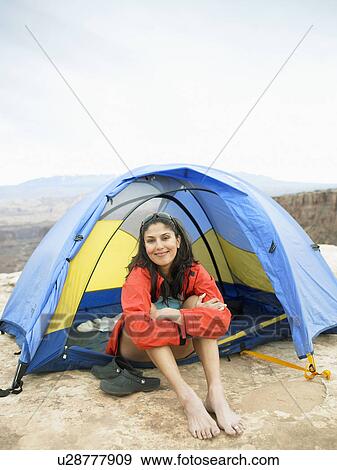 Stock Photo - Woman sitting in tent, portrait. Fotosearch