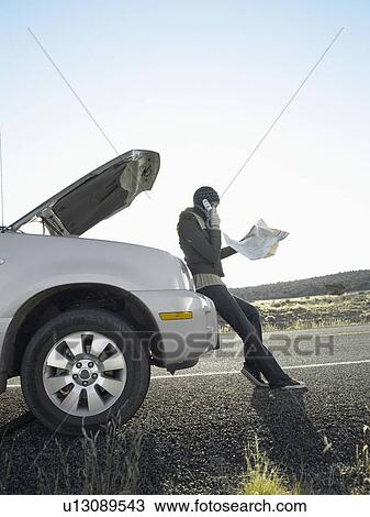 Woman with road map talking on cell phone by broken car View Large Photo Image Stock Image - Woman with road map talking on cell phone by broken car. Fotosearch