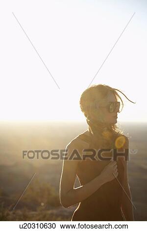 Stock Image - Young woman in desert (lens flare), Arizona, USA. Fotosearch