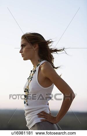 Young woman looking at view at sunset View Large Photo Image Stock Image - Young woman looking at view at sunset. Fotosearch