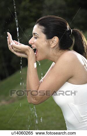 Young woman catching flowing water in hands View Large Photo Image Stock Photography - Young woman catching flowing water in hands. Fotosearch