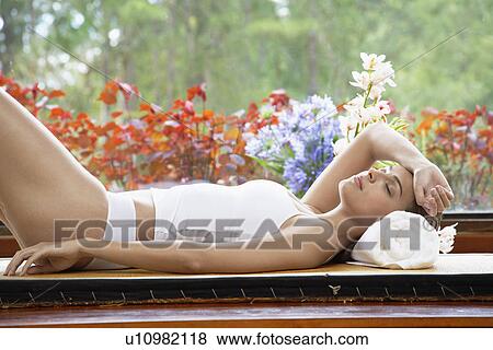 Stock Photo - Young woman lying near window. Fotosearch