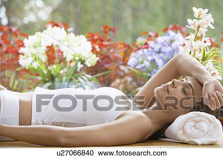 Young woman lying with head on rolled towel View Large Photo Image Stock Image - Young woman lying with head on rolled towel. Fotosearch