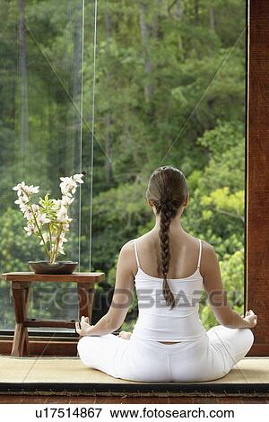 Young woman meditating on tatami mat near window, rear view View Large Photo Image Stock Photo - Young woman meditating on tatami mat near window, rear view. Fotosearch