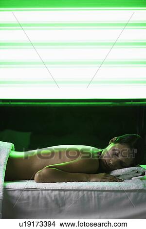 Picture - Young woman receiving light therapy. Fotosearch