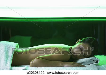 Stock Image - Young woman receiving light therapy. Fotosearch