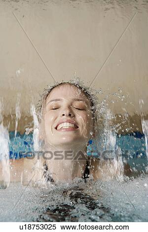 Stock Photography - Young woman under waterfall in spa. Fotosearch