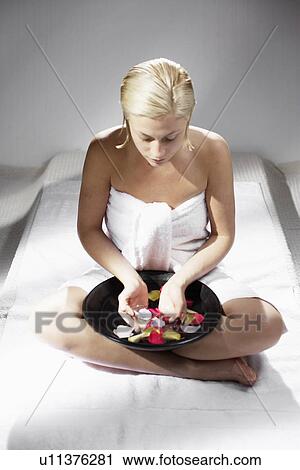 Stock Image - Young woman with bowl of rose water. Fotosearch