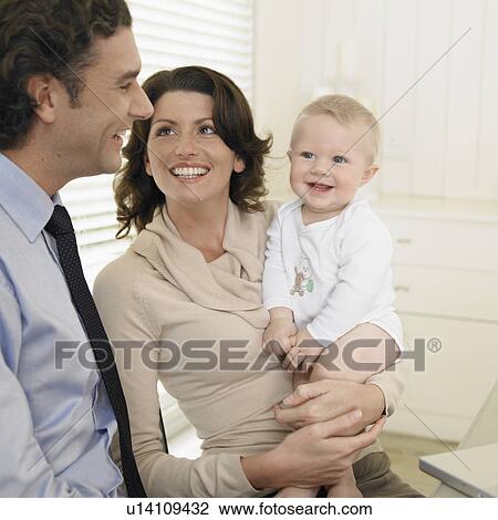 Stock Image - Mid adult couple with baby boy (0-6 months). Fotosearch