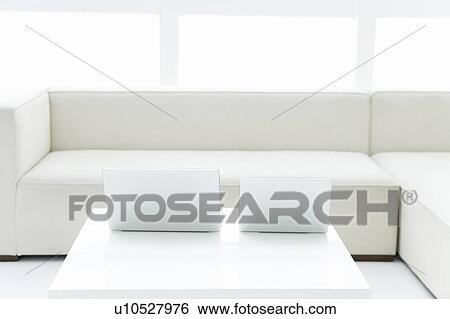 Laptops on a table in a living room View Large Photo Image Stock Photograph - Laptops on a table in a living room. Fotosearch