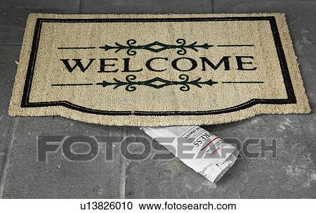 Stock Image - Newspaper under doormat (close-up). Fotosearch