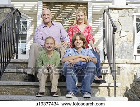 Picture - Family of four sitting on steps. Fotosearch