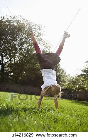 Girl (10-11) standing on hands on lawn View Large Photo Image Stock Photo - Girl (10-11) standing on hands on lawn. Fotosearch